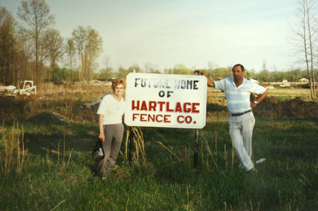 Ken and Mary Hartlage posing in front of company sign after acquisition from Sid Hartlage.